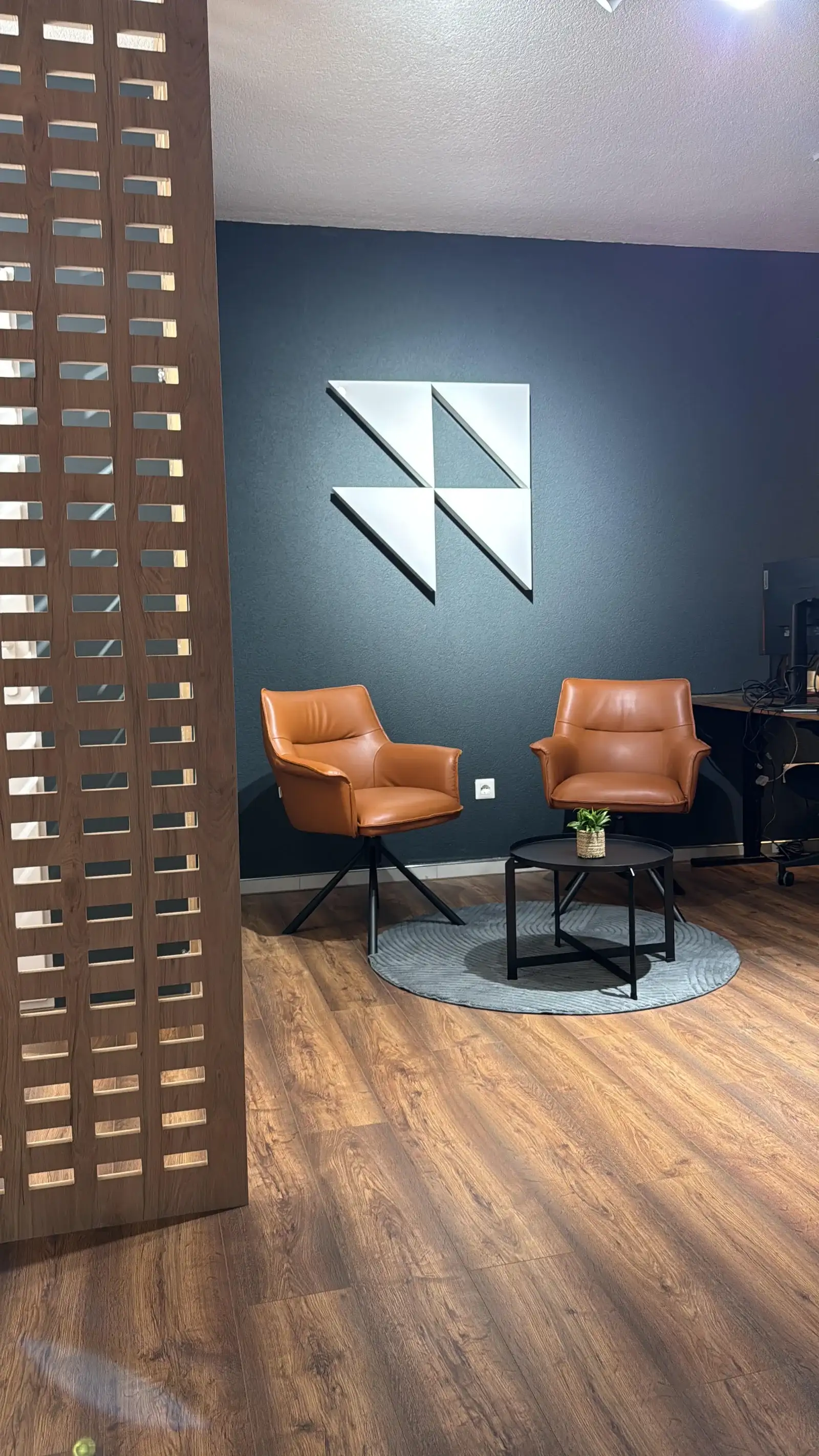 The RDR Digital studio: two leather chairs beneath our geometric wall logo